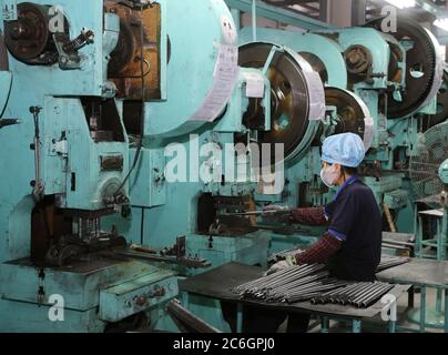 Lokale Arbeiter sind damit beschäftigt, in einer Werkstatt in einer Maschinenfabrik, in der Stadt Libao, in der Stadt Hai'an auf Kreisebene, in der Stadt Nantong, im ostchinesischen Jiangsu Pro zu produzieren Stockfoto