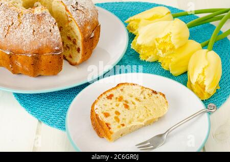 Hausgemachte Kuchen, gelbe Tulpen auf weißem Holztisch. Stockfoto