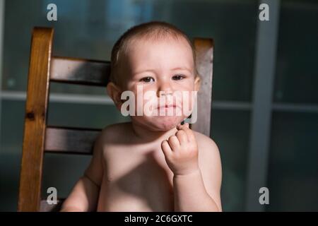 Liebenswert Baby Junge essen Hüttenkäse aus Löffel, gesunde Milch Snack. Stockfoto