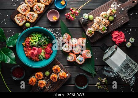 Tisch serviert mit Sushi, Brötchen und traditionellen japanischen Speisen auf dunklem Hintergrund. Draufsicht. Stockfoto