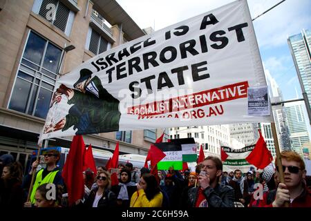 Die sozialistische Alternative trägt ein Banner mit der Aufschrift: ‘Israel ist ein terroristischer Staat’, während sie entlang der George Street, Sydney zur Unterstützung Palästinas und wieder marschieren Stockfoto