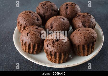 Teller voll mit Schokolade Muffins auf dunklem Hintergrund. Köstliches Schokoladendessert. Stockfoto