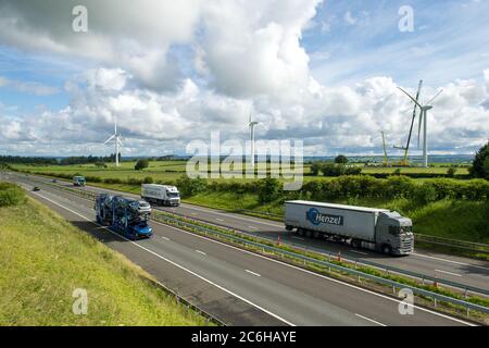 Larkhall, Schottland, Großbritannien. Juli 2020. Im Bild: Eine riesige Windkraftanlage steht ein paar hundert Meter hoch mit einem massiven Industriekran mit einem Verlängerungskräne am Ende, um zusätzliche Höhe Stände neben der Turbine halten die Blattstruktur an Ort und Stelle zu geben. Grüne Energie ist ein großes Geschäft, und wenn Großbritannien seine Ziele für erneuerbare Energien archivieren soll, müssen mehr Windenergieanlagen an Land und auf See gebaut werden. Quelle: Colin Fisher/Alamy Live News Stockfoto