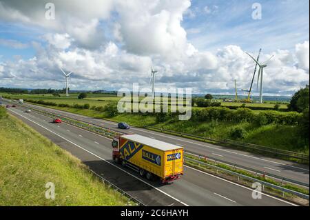 Larkhall, Schottland, Großbritannien. Juli 2020. Im Bild: Eine riesige Windkraftanlage steht ein paar hundert Meter hoch mit einem massiven Industriekran mit einem Verlängerungskräne am Ende, um zusätzliche Höhe Stände neben der Turbine halten die Blattstruktur an Ort und Stelle zu geben. Grüne Energie ist ein großes Geschäft, und wenn Großbritannien seine Ziele für erneuerbare Energien archivieren soll, müssen mehr Windenergieanlagen an Land und auf See gebaut werden. Quelle: Colin Fisher/Alamy Live News Stockfoto