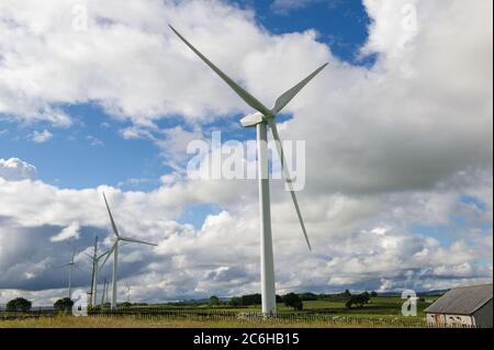 Larkhall, Schottland, Großbritannien. Juli 2020. Im Bild: Eine riesige Windkraftanlage steht ein paar hundert Meter hoch mit einem massiven Industriekran mit einem Verlängerungskräne am Ende, um zusätzliche Höhe Stände neben der Turbine halten die Blattstruktur an Ort und Stelle zu geben. Grüne Energie ist ein großes Geschäft, und wenn Großbritannien seine Ziele für erneuerbare Energien archivieren soll, müssen mehr Windenergieanlagen an Land und auf See gebaut werden. Quelle: Colin Fisher/Alamy Live News Stockfoto