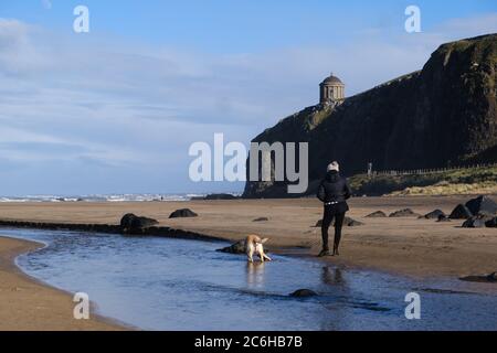 Lady mit goldenem Labrador am Downhill Beach, Blick Richtung Mussenden Tempel bei Castlerock in Nordirland Stockfoto