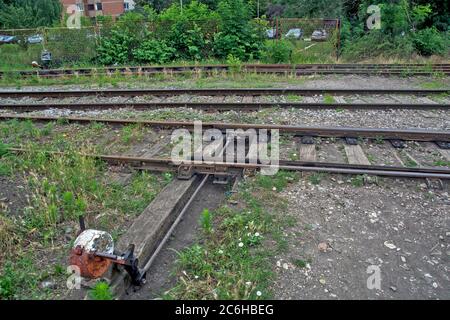 Zrenjanin, Serbien, 04. Juli 2020. Die Eisenbahn ist vernachlässigt, verwüstert, veraltet und mit Gras bewachsen. Manuelle Schaltanlage, die zwei Gleisschienen verbindet Stockfoto