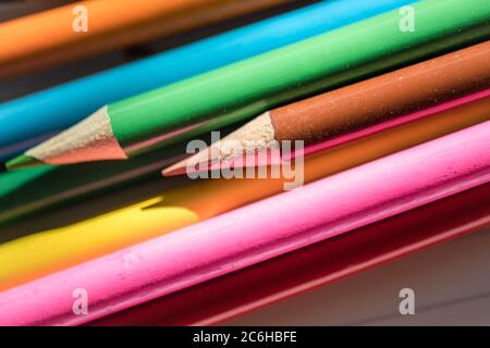 Flache Fokusansicht eines Nahaufnahme-Bildes mit neuen Farbstiften auf leerem Schreibpapier. Detail von einigen der Färbung Bleistift Tipps ist offensichtlich. Stockfoto