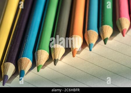 Flache Fokusansicht eines Nahaufnahme-Bildes mit neuen Farbstiften auf leerem Schreibpapier. Detail von einigen der Färbung Bleistift Tipps ist offensichtlich. Stockfoto