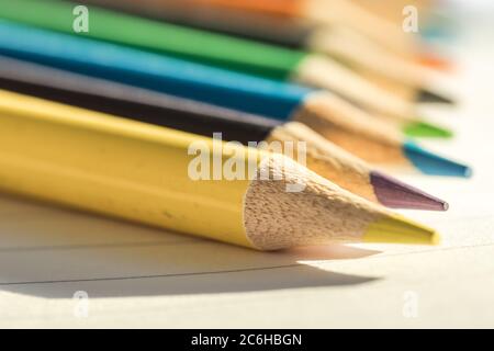 Flache Fokusansicht eines Nahaufnahme-Bildes mit neuen Farbstiften auf leerem Schreibpapier. Detail von einigen der Färbung Bleistift Tipps ist offensichtlich. Stockfoto