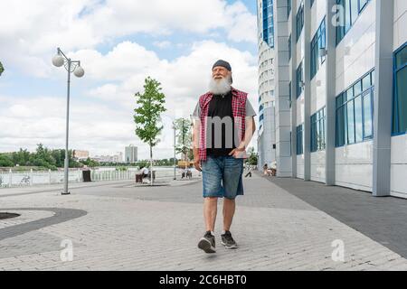 Porträt eines älteren Mannes in legerer Kleidung, der wegschaut. Reifer Mann mit Bart zu Fuß Straße an einem Sommertag. Stockfoto