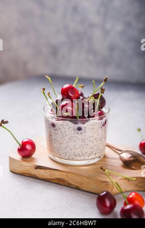 Chia Pudding mit Kirschbeeren, Naturjoghurt, in einem Glas auf einer grauen Oberfläche. Selektiver Fokus. Gesunde Nachtisch, richtige Ernährung, super Essen. Stockfoto