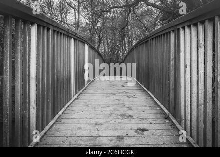 Abstrakte Ansicht eines Holzfußbrückenbaus mit Details des Designs und der Konstruktion. Über einen Binnenfluss. Stockfoto