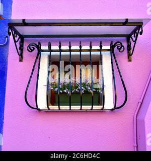 Burano Insel, Venedig. Dekoriertes Fenster mit Blumenstrauß. Bunte Häuser Insel und Wahrzeichen der Region Venetien, Italien Stockfoto