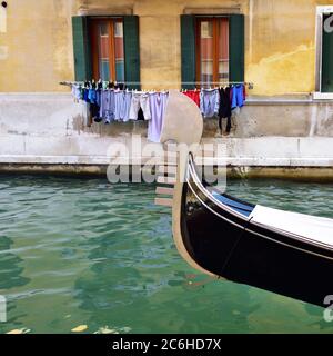 Prow der Gondel auf dem venezianischen Wasserkanal mit und Übergabe von Leinen auf Hintergrund bunte Fassade. Venedig, Italien Stockfoto