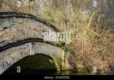 Nahaufnahme einer alten und verwitterten Ziegelsteinbrücke, die über eine Brücke führt. Stockfoto