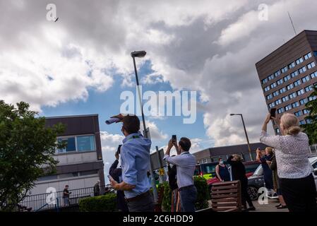 Basildon University Hospital, Essex, Großbritannien. Juli 2020. Die Aircraft Restoration Company mit Sitz auf dem Flugplatz Duxford in Cambridgeshire hat zu Ehren der Arbeiten während der COVID-19 Coronavirus-Pandemie auf der Unterseite ihrer blauen Spitfire 'THANK U NHS' gemalt und sie bei besonderen Anlässen um die Gegend geflogen. Heute flogen sie es weiter über eine Reihe von Krankenhäusern, darunter Basildon. Die Spitfire ist eine Photo Reconnaissance PRXI Version, Seriennummer PL983, und blau lackiert für Tarnung auf hohen Ebenen während des Zweiten Weltkriegs. Viele Mitarbeiter des Gesundheitswesens kamen heraus, um zuzusehen Stockfoto