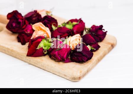 Trockene Rosenblätter. Getrocknete violette Rosenknospen auf Holztafel. Stockfoto