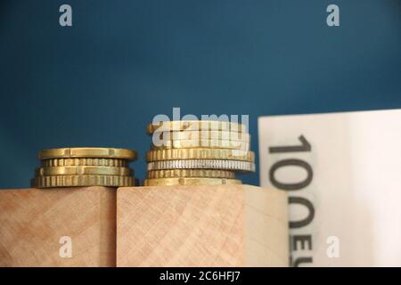 2 Stapel Euro-Münzen und 100 Euro-Scheine. Business Profit-Konzept Stockfoto