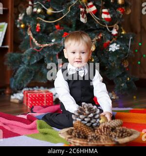 Kleiner Junge in Weihnachtsschmuck erwarten ein Wunder Stockfoto