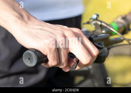 Nahaufnahme einer mans Hand, die das Fahrrad-Lenkrad hält und die Bremse gedrückt hält. Stockfoto