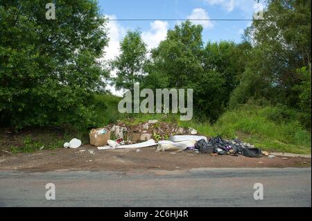 Larkhall, Schottland, Großbritannien. Juli 2020. Bild: Illegal abgeworfener Müll auf einer ruhigen Straße. Fly-Kipping kostet die britischen Räte Millionen pro Jahr, um ordnungsgemäß zu entsorgen. Während der Sperrung des Coronavirus (COVID19) werden vom rat geschlossene Abfallentsorgungszentren betrieben, sodass die Menschen ihren Müll lagern können, der nicht bereits in den Mülldeponie entsorgt werden konnte. Andere Menschen haben sich dazu gegriffen, ihren Müll auf dem Land zu deponien. Quelle: Colin Fisher/Alamy Live News Stockfoto