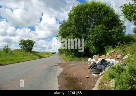 Larkhall, Schottland, Großbritannien. Juli 2020. Bild: Illegal abgeworfener Müll auf einer ruhigen Straße. Fly-Kipping kostet die britischen Räte Millionen pro Jahr, um ordnungsgemäß zu entsorgen. Während der Sperrung des Coronavirus (COVID19) werden vom rat geschlossene Abfallentsorgungszentren betrieben, sodass die Menschen ihren Müll lagern können, der nicht bereits in den Mülldeponie entsorgt werden konnte. Andere Menschen haben sich dazu gegriffen, ihren Müll auf dem Land zu deponien. Quelle: Colin Fisher/Alamy Live News Stockfoto