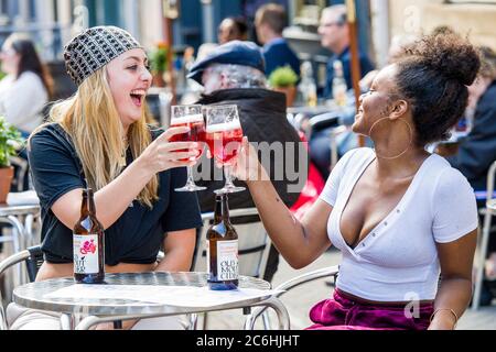 (L-R) Chloe Mills (19) und Freund Abigail De Souza (19) genießen ihre ersten Drinks in einem Pub im 'Dirty Dicks' in der Rose Street, da Schottland die Beschränkungen geändert hat, damit Biergärten geöffnet werden können. Schottland befindet sich in einer 16. Woche der Sperre aufgrund des Covid-19-Ausbruchs. Kredit: Euan Cherry Stockfoto