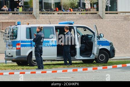 Hannover, 23. Mai 2020: Polizeiwagen mit Polizisten, die vor ihm am Rande einer Demonstration hinter einer Schranke warten Stockfoto