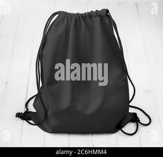 Schwarzer Rucksack mit Schnüren auf Planken Stockfoto