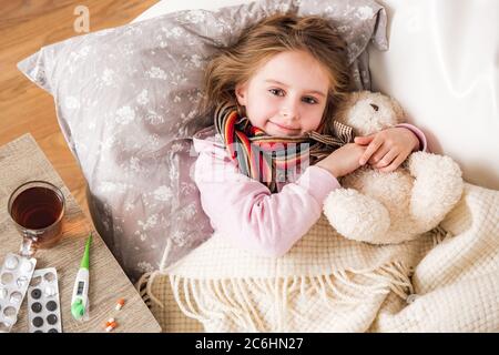 Kleine kranke Mädchen schlafen umarmt Teddybär Stockfoto