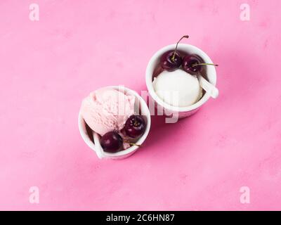 Zwei Eisbecher mit Kirschen auf rosa Stockfoto