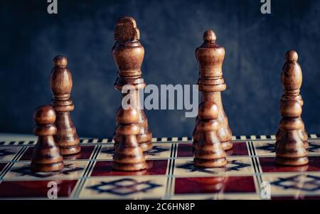 Klassische Holzschach-Figuren mit Reflexion an Bord vorne Stockfoto
