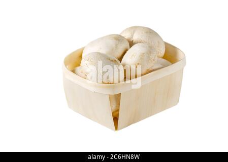Champignons in Holzkörbchen auf weißem Hintergrund. Nahaufnahme isoliert auf weißem Hintergrund. Gepackte Champignons in den Korb. Stockfoto