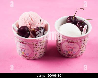 Zwei Eisbecher mit Kirschen auf rosa Stockfoto