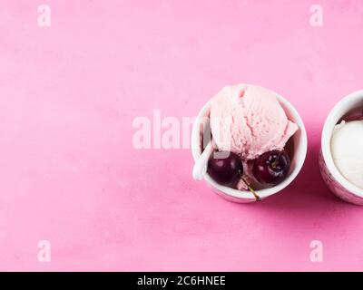 Zwei Eisbecher mit Kirschen auf rosa Stockfoto