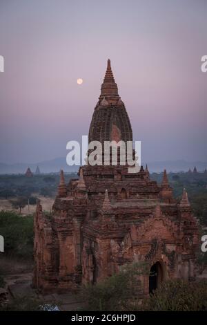 Der Mond steigt über den Tempeln und Pagoden bei Sonnenaufgang in Old Bagan, Myanmar Stockfoto