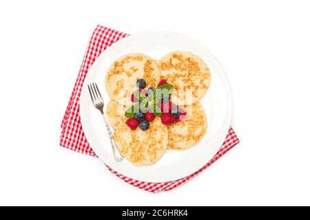 Pfannkuchen mit Himbeeren und Heidelbeeren auf einem weißen Teller und auf weißem Hintergrund in der Draufsicht Stockfoto