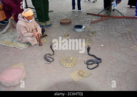 Marrakesch, Marokko - 22. November 2014: Nicht identifizierter Schlangenbeschwörer und Schlangen auf dem Platz Djemaa el-Fna - ein UNESCO-Weltkulturerbe Stockfoto