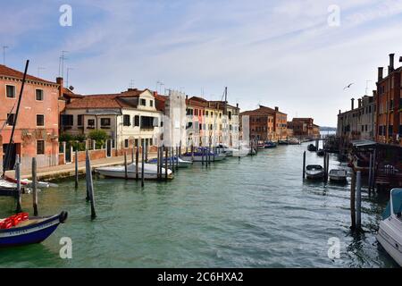 VENEDIG, ITALIEN - 24. SEPTEMBER 2014: Giudecca Insel, Kanal und Boot bei Sonnenuntergang. Venedig und die venezianische Lagune sind auf der UNESCO-Liste des Weltkulturerbes Stockfoto