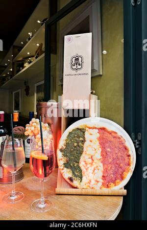 Garnierte Pizza, die die italienische Flagge darstellt, vor einem italienischen Pizzeria-Restaurant zur Zeit des Coronavirus 19. Rom, Italien, Europa Stockfoto