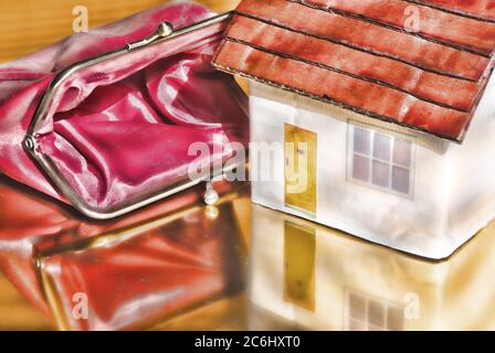 Bild des Finanzkonzepts. Kosten von Covid 19 zu Wirtschaft und Einsparungen. Spielzeughaus. Leere Geldbörse. Idee Mangel an Bargeld, Kosten von Virus für Einzelpersonen. Stockfoto