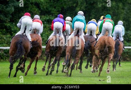 Hamburg Horn, Deutschland. Juli 2020. Pferderennen: Galopp, Derby Hamburg: Im Regen galoppieren die Jockeys auf ihren Pferden über die Strecke. Aufgrund der Corona-Pandemie wird das Galopptreffen auf drei Tage verkürzt und findet erstmals ohne Zuschauer statt. Quelle: Daniel Bockwoldt/dpa/Alamy Live News Stockfoto