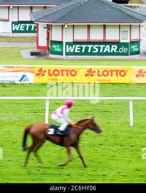 Hamburg Horn, Deutschland. Juli 2020. Pferderennen: Galopp, Derby Hamburg:EIN Jockey reitet auf einem Pferd an einem geschlossenen Wettbüro vorbei. Aufgrund der Corona-Pandemie wird das Galopptreffen auf drei Tage verkürzt. Quelle: Daniel Bockwoldt/dpa/Alamy Live News Stockfoto