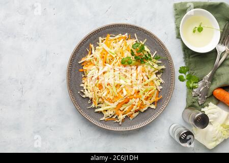 Frischer Krautsalat aus geriebenem Kohl und Karotte auf weißem Hintergrund. Draufsicht. Stockfoto