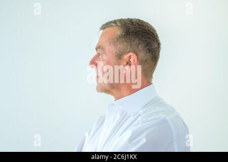 Seitenansicht eines ernsthaften Mannes mittleren Alters mit deadpan Expression Stockfoto