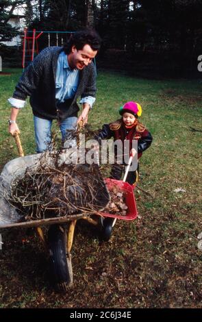 Kay Sabban, deutscher Schauspieler, sammelt mit seiner Tochter Laub im Garten in Hamburg, Deutschland 1990. Stockfoto