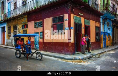 Havanna, Kuba, Juli 2019, Taxi-Dreirad bei einem Lebensmittelgeschäft an der Ecke Calle Muralla & Cuba im ältesten Teil der Stadt Stockfoto