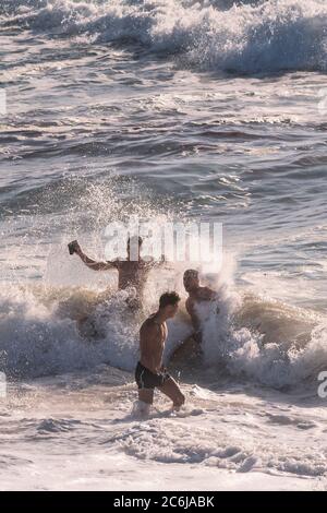 Junge männliche Urlauber verbringen ihren Urlaub am Fistral Beach in Newquay in Cornwall. Stockfoto