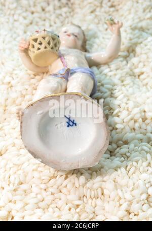 Blau gekreuzte Schwerter-Markierung auf einer antiken Meissener Porzellanfigur Cherub Boy mit Blumenkorb Stockfoto